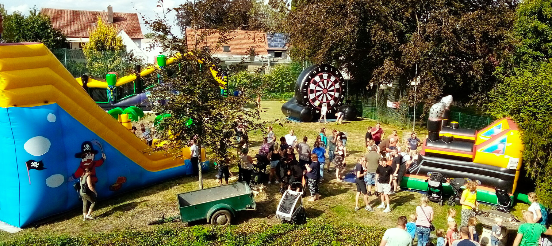 Das Spielfest der evangelische Jugend im Garten des Rauchfangs in Stift Quernheim. Es sind verschiedene Großspielgeräte aufgebaut und viele Menschen zu sehen.